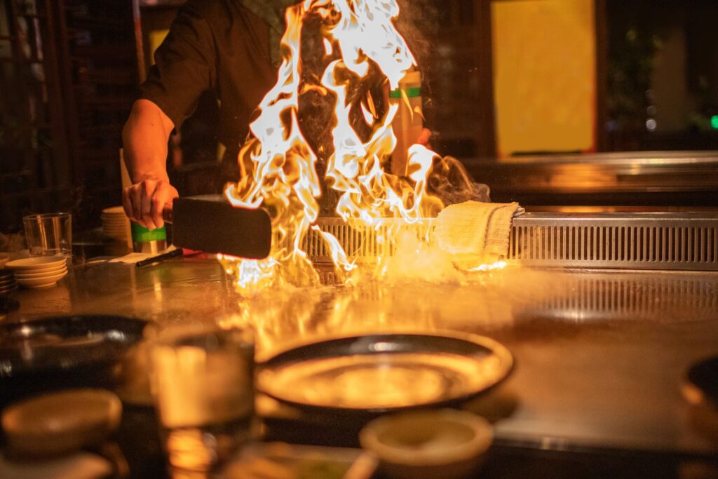 Image of chef with flames from teppanyaki cooking in front of him