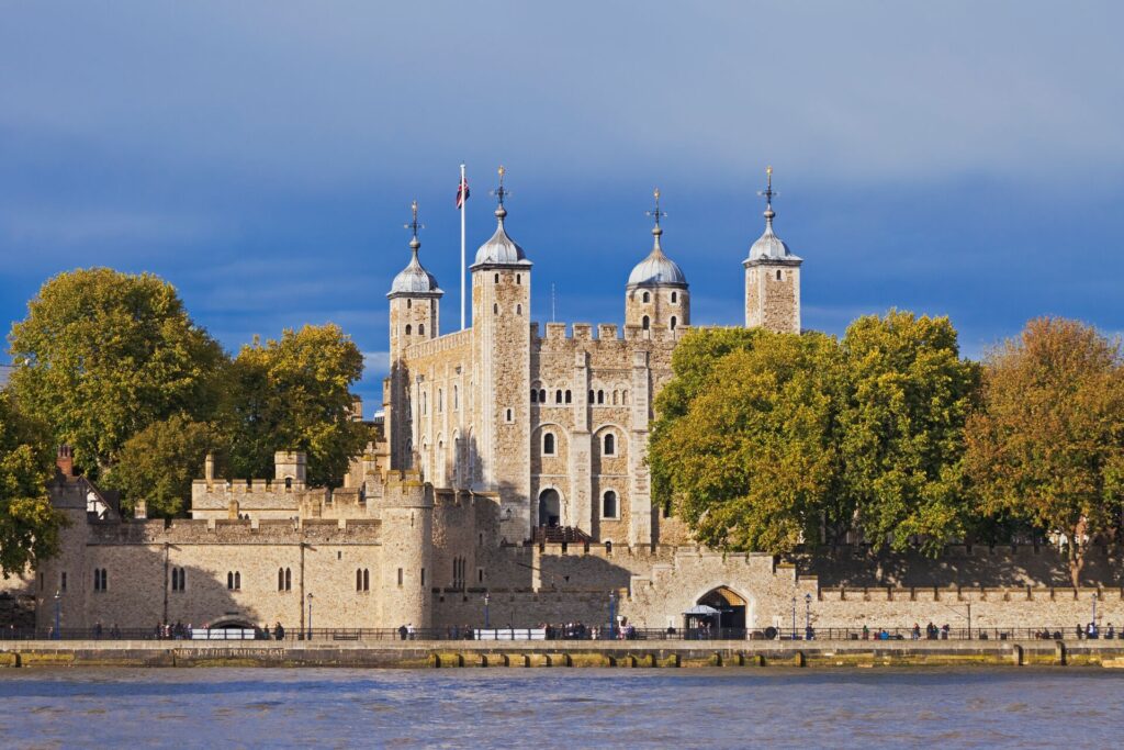 Image of the Tower of London against a clear blue sky with the Thames flowing in front