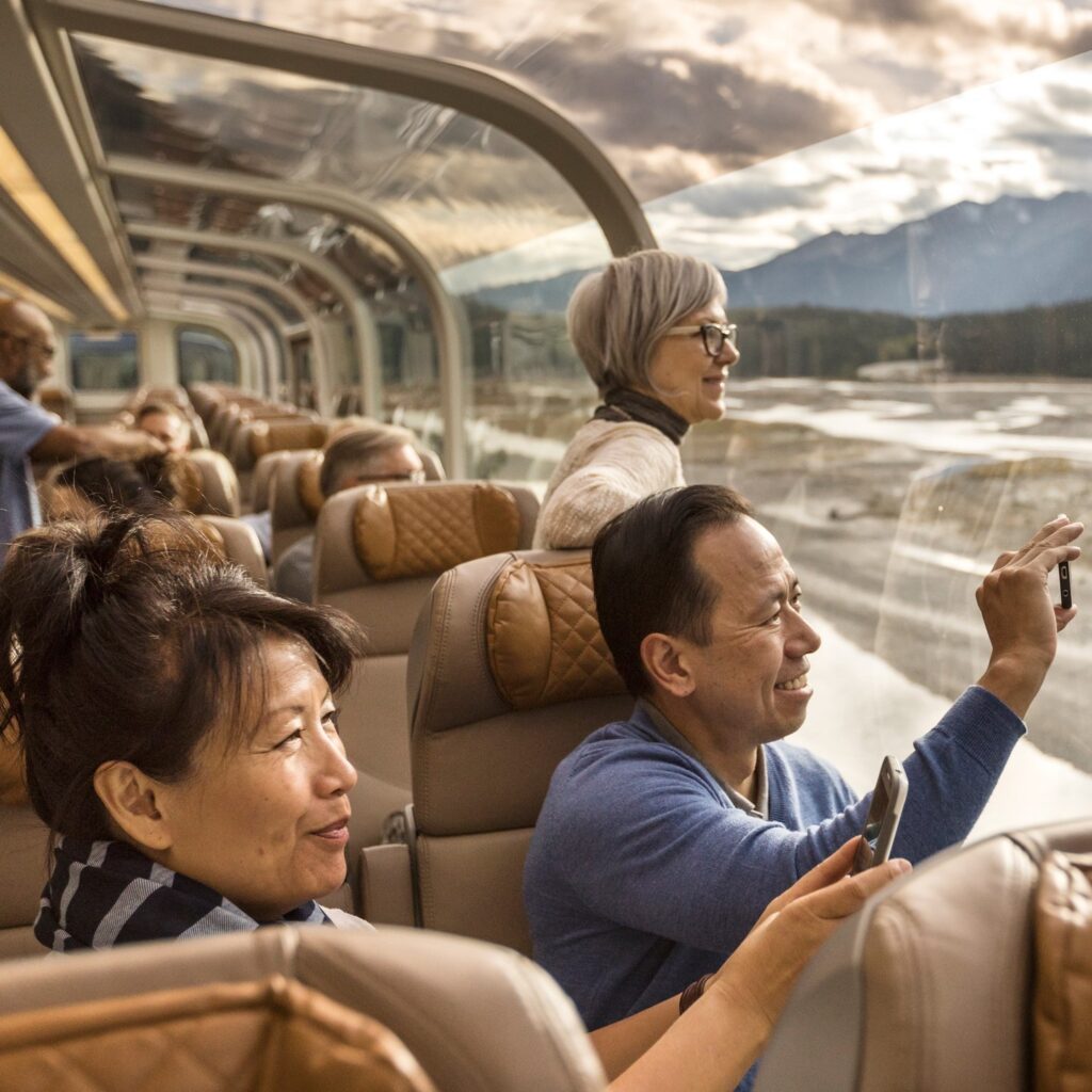 passengers looking at the views from the GoldLeaf carriages of the Rocky Mountaineer train