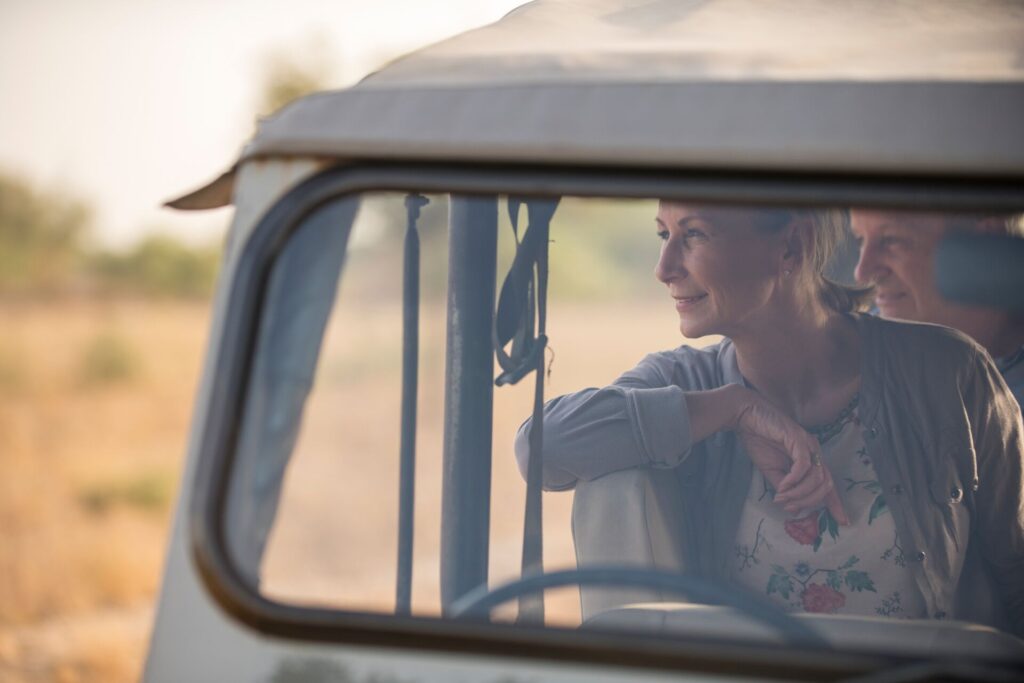 Image of lady sitting in private safari jeep, looking out over the African bushland