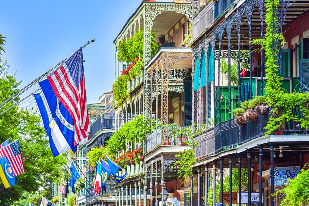 Image of colourful New Orleans street, with flags and ornate balconies with blooming flowers