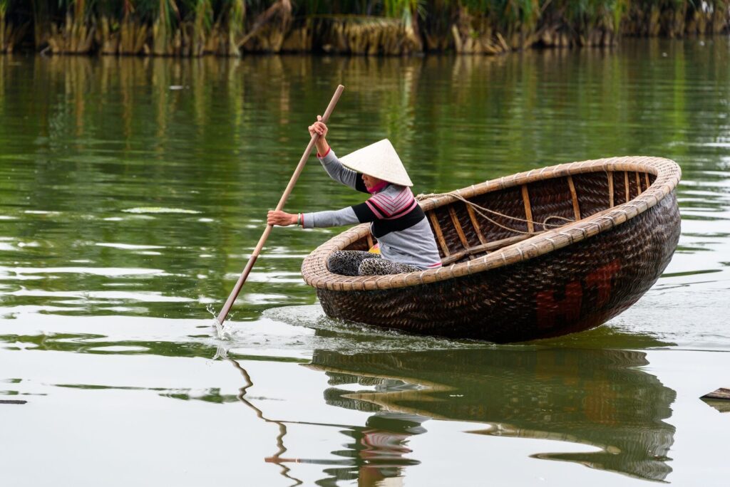 man rowing a bamboo boat basket in Vietnam