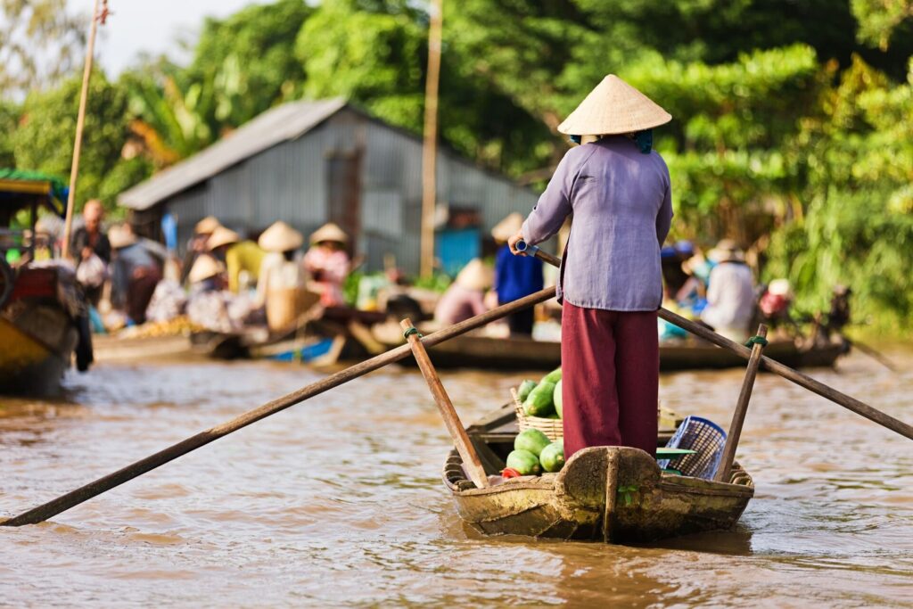 Woman rowing a boat on the Mekong River Vietnam
