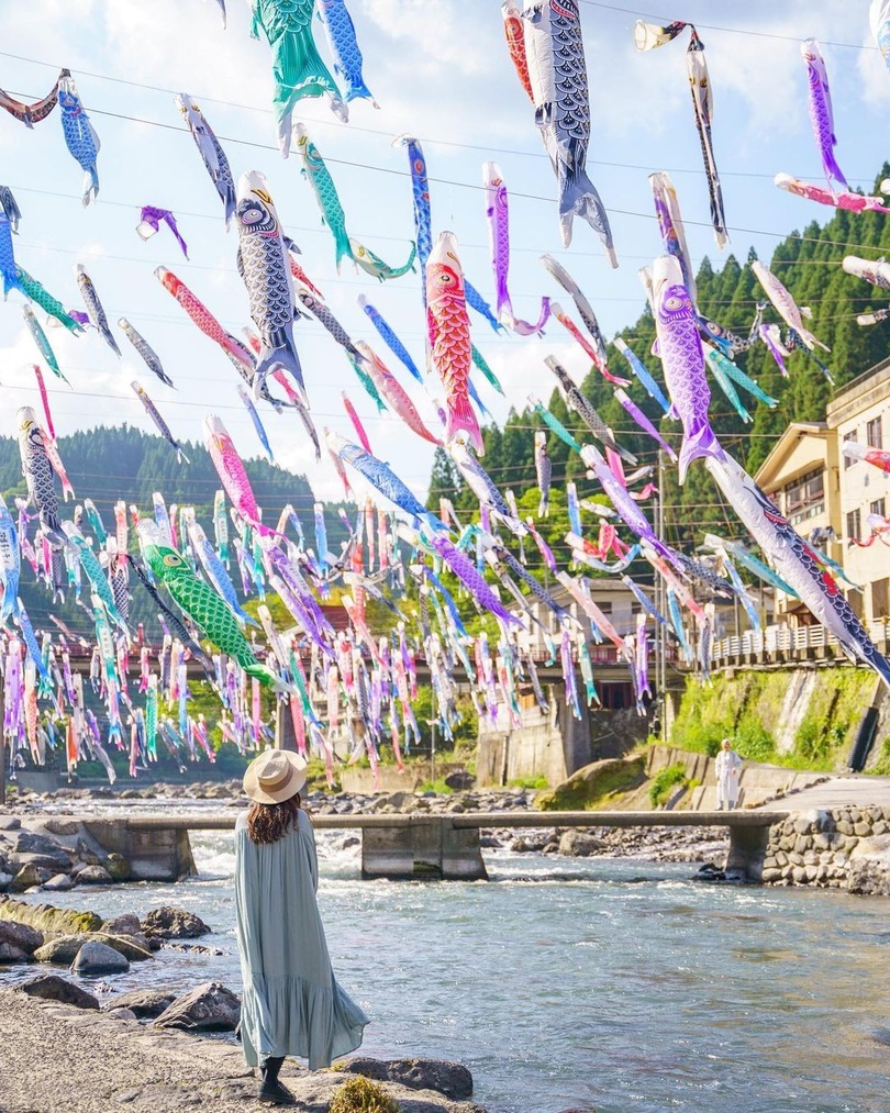 colourful fish decorations strung up over a river Japan