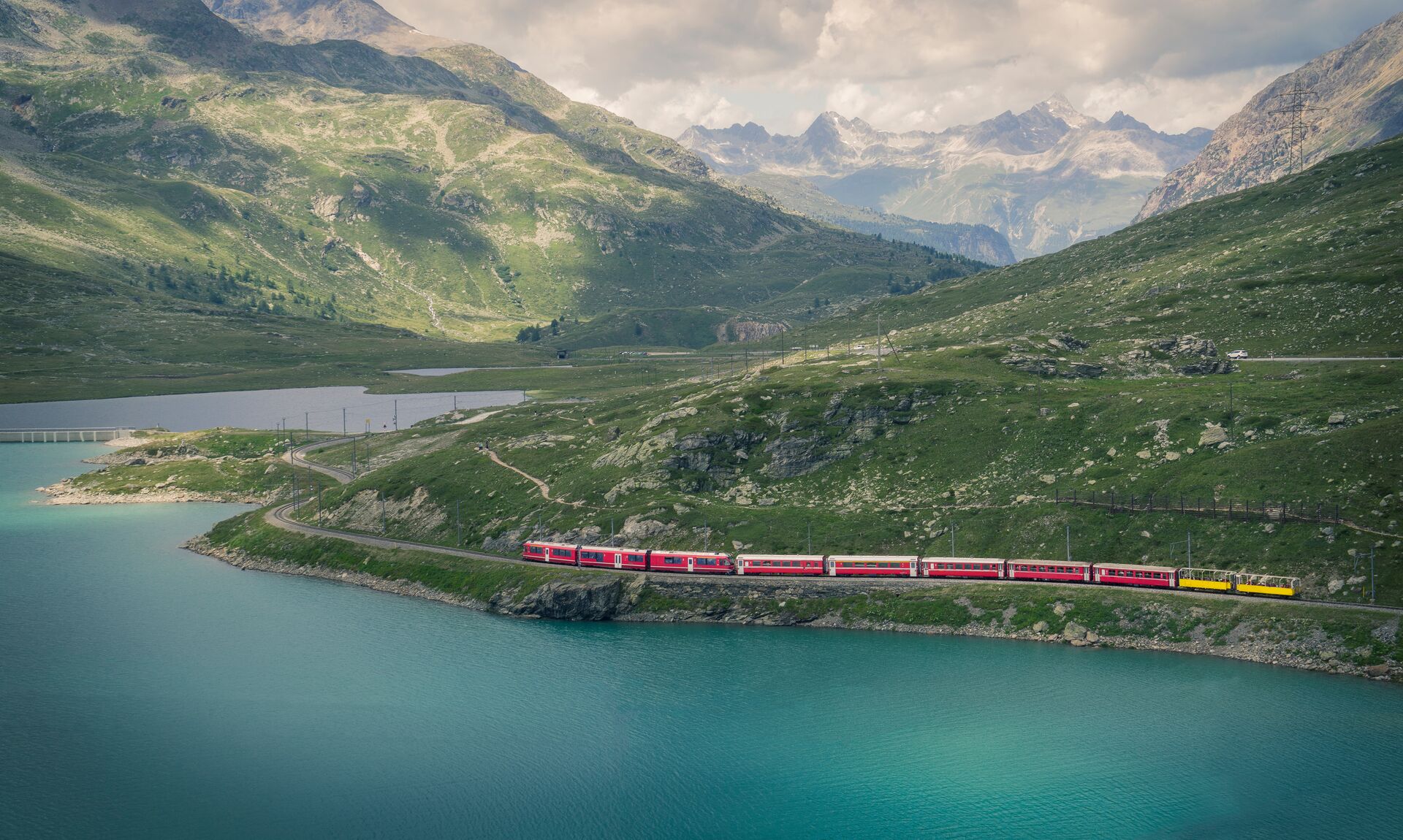 Glacier Express train winding past a glacial lake in Switzerland
