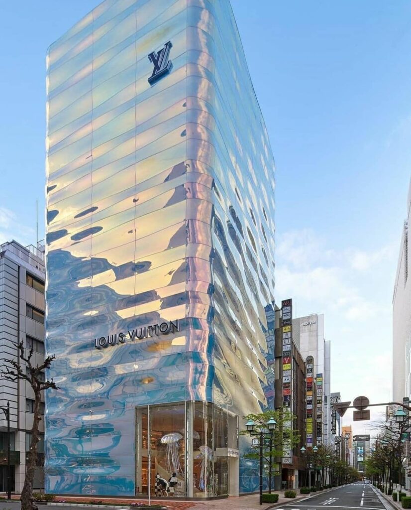 Image of futuristic Louis Vitton story in Tokyo, tall, silver and shining like it is covered in water