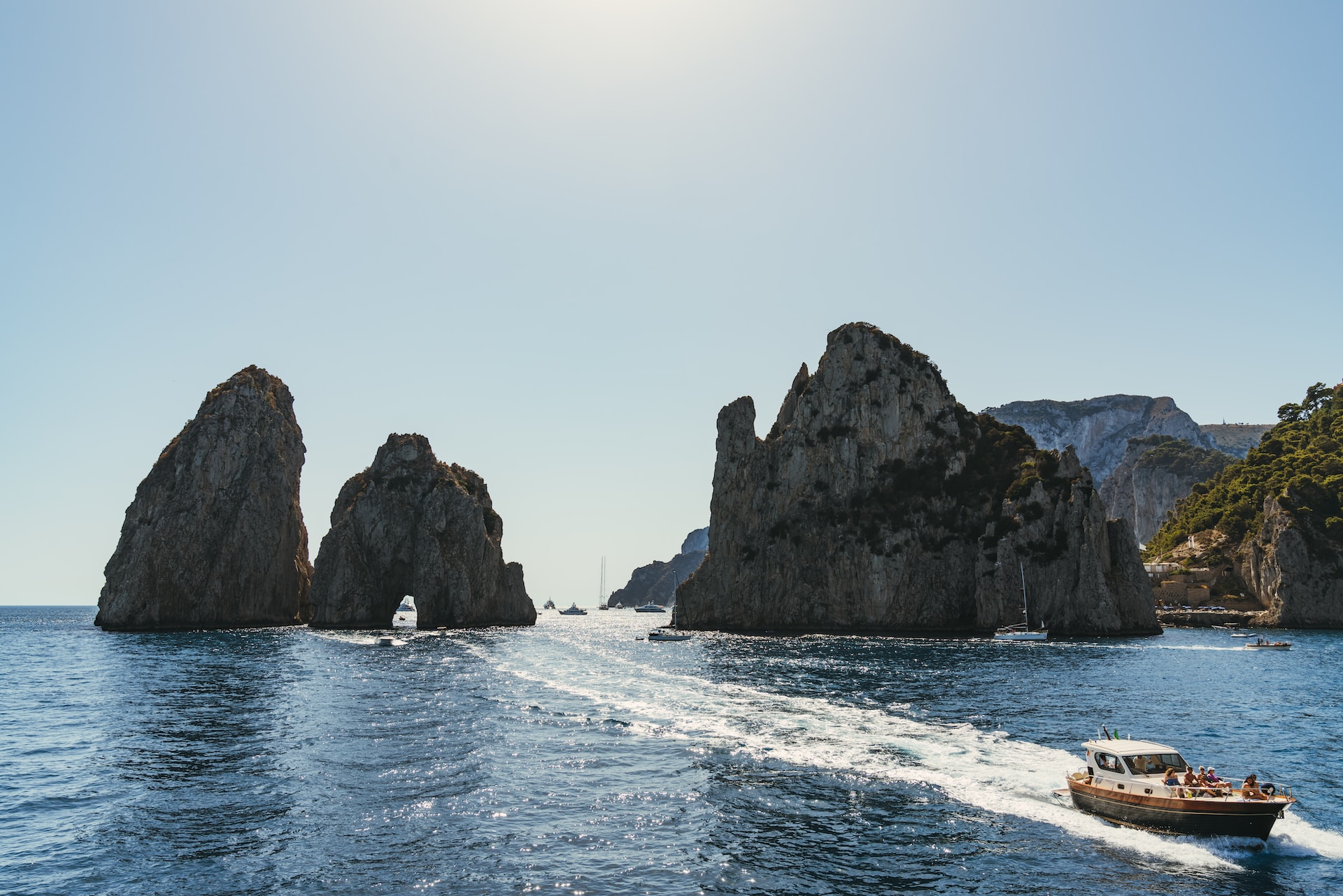 A boat cruising along Capri's rocky coastline 