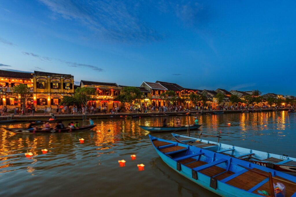 Glowing houses lining the canal at night in Hue Vietnam