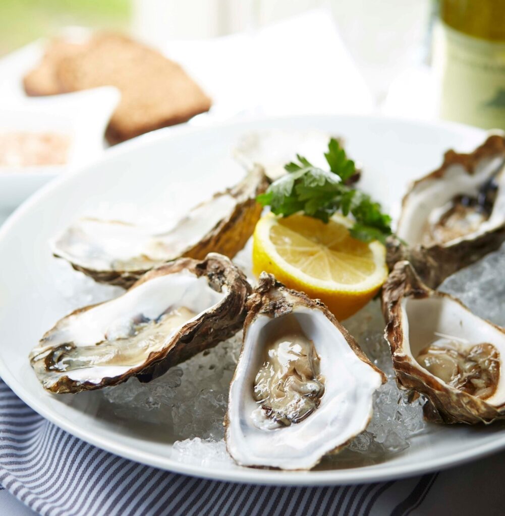 Seasonal oysters served shucked on a bed of ice with lemon in the middle