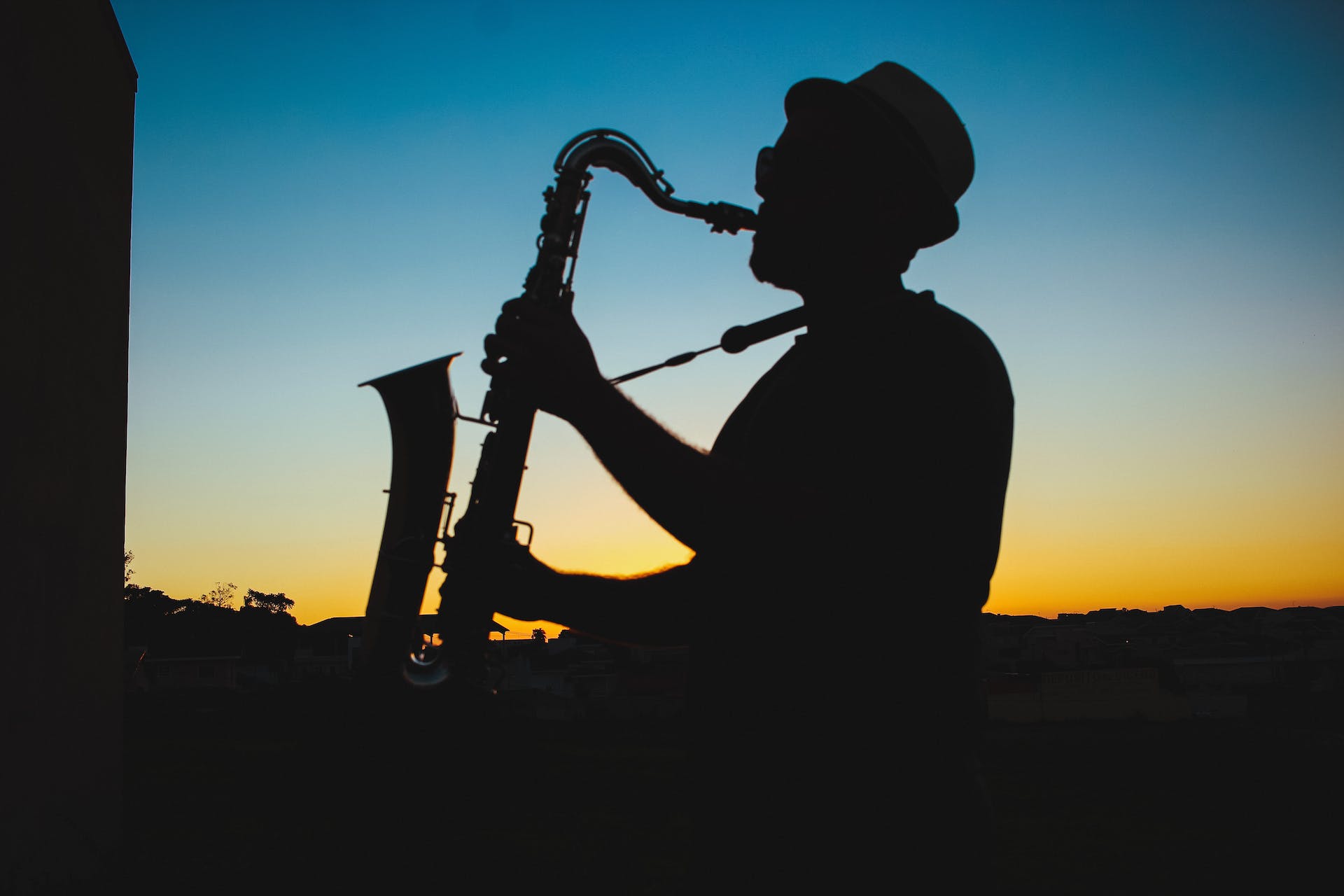 Silhouette of man playing saxophone at sunset
