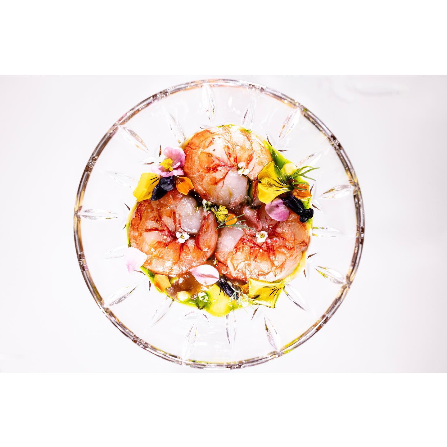 Plate of prawns on glass plate with white background at Maison Ruggieri restaurant 