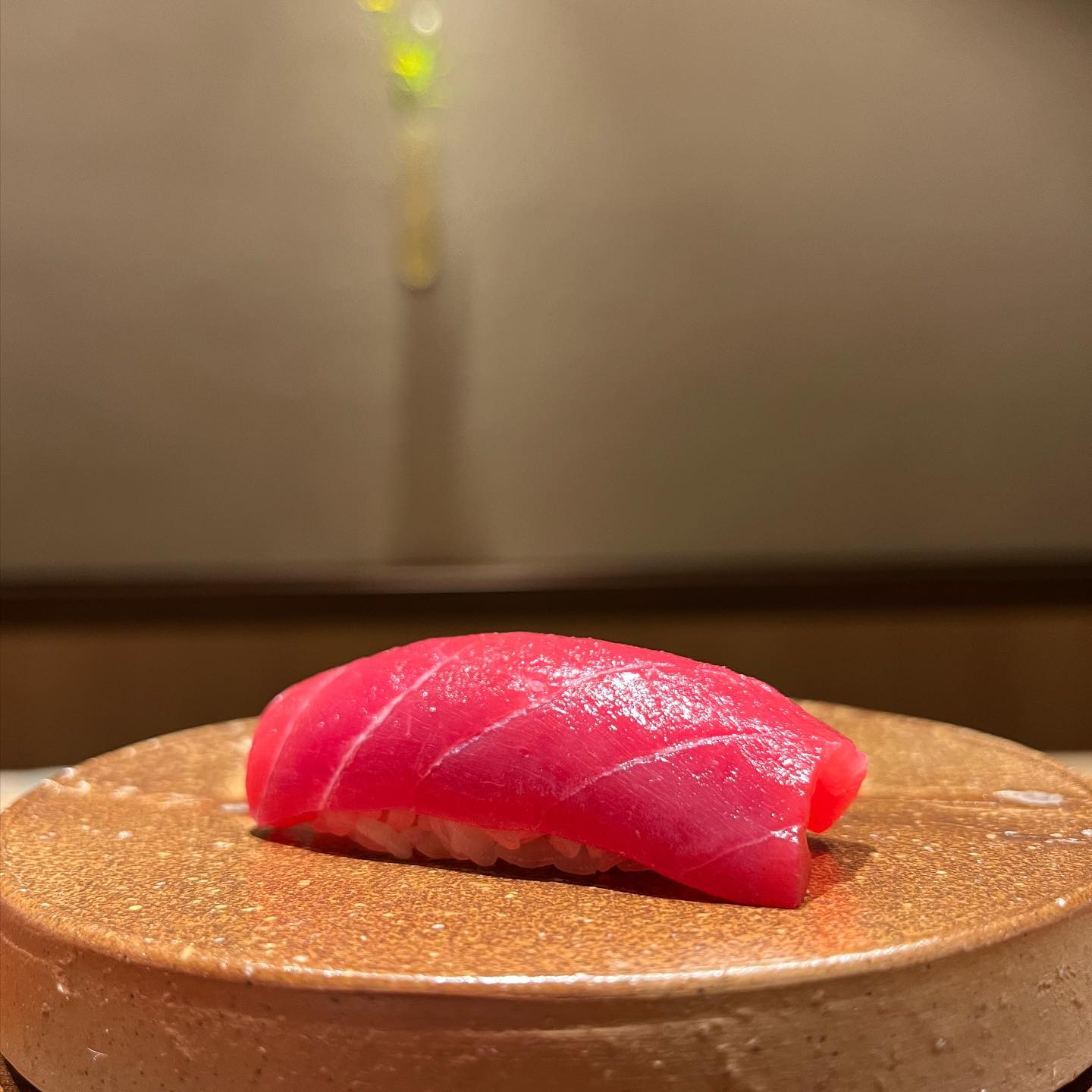Plate of red fish sushi on brown plate at Hiroo Ishizaka sushi bar