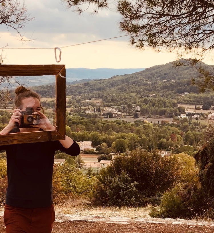 Travel Concierge Helen pictures taking a picture through a picture frame in the Southern France countryside