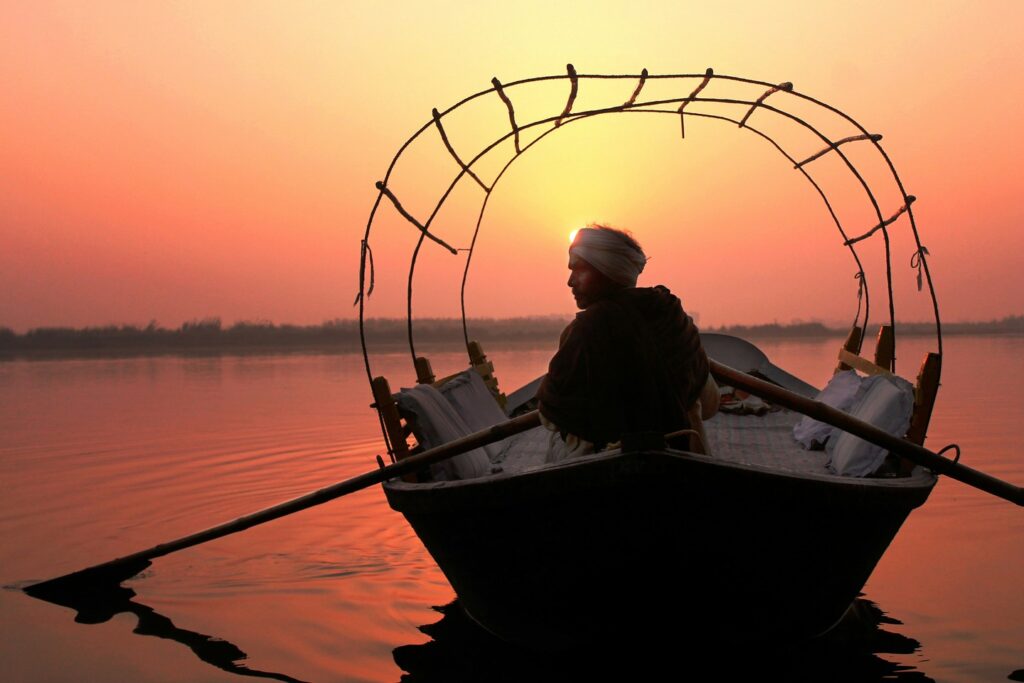 man sailing a boat on the Ganges at sunrise