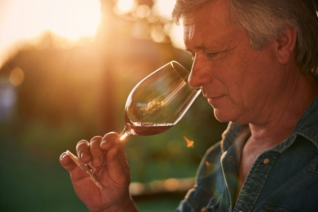 Mature male smelling a glass of red wine